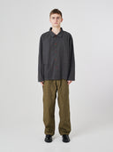 Full-length view of man wearing an Uskees charcoal-grey cotton overshirt paired with khaki-green pants.