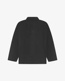 Back view of charcoal-grey, buttoned corduroy overshirt with view of reinforced elbow area and boxy silhouette.