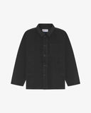 Front flat shot of charcoal-grey, buttoned corduroy overshirt. Clear view of chest and hip pockets, corozo buttons and Uskees branding label.