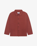 Front flat shot of chestnut-brown, buttoned drill overshirt. Clear view of corozo buttons, 3 pockets and Uskees branding label.