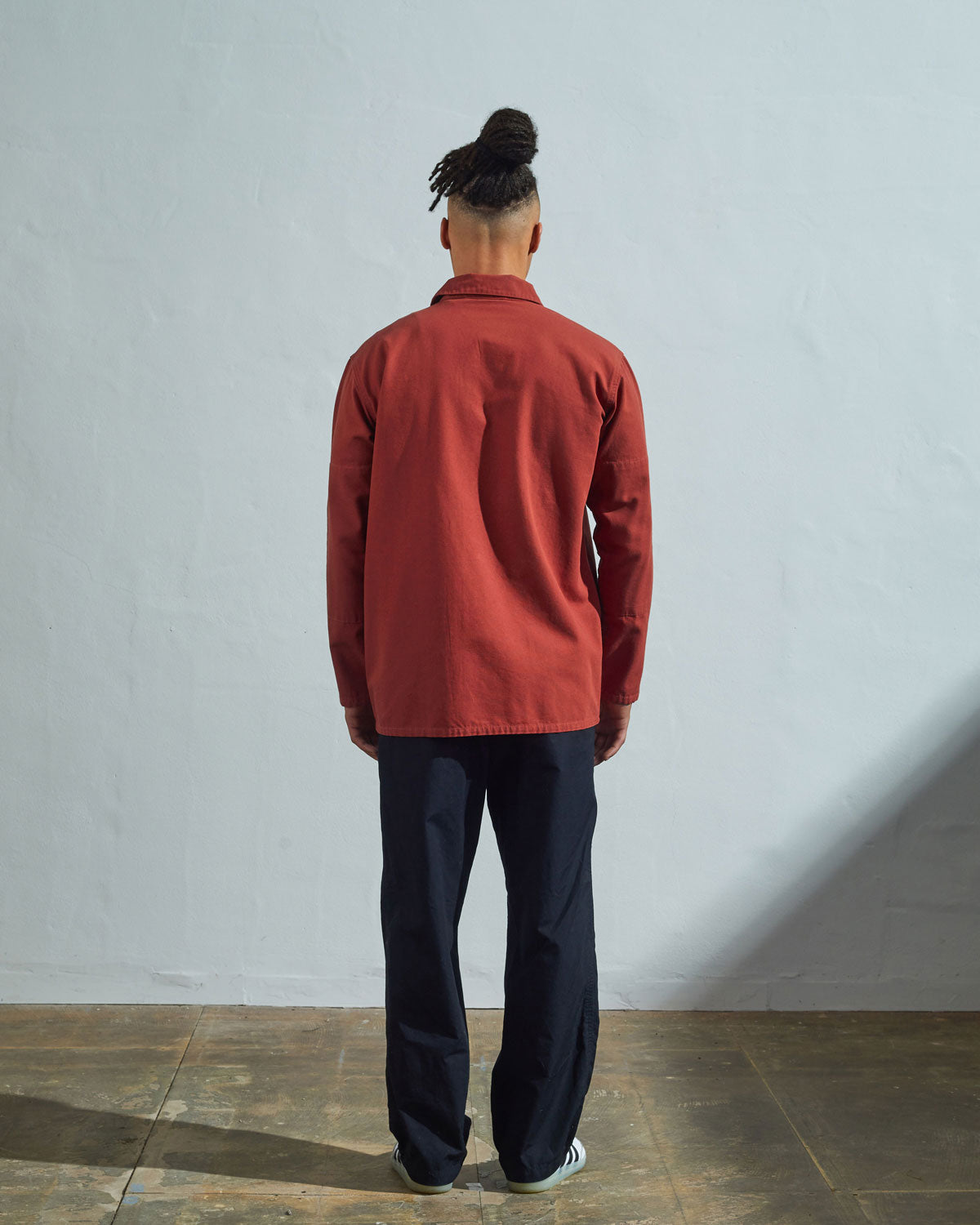 Full-length rear view of model wearing #3001, 'clay' over shirt with reinforced elbows.