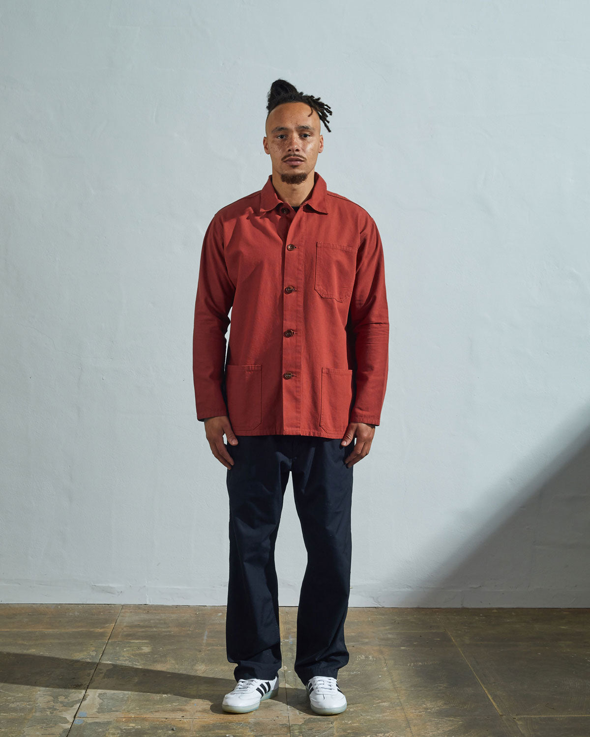 Full-length frontal view of model wearing #3001, terracotta red overshirt paired with dark blue jeans.