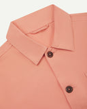 Close-up view of 3001 pink-orange (coral), buttoned organic cotton overshirt from Uskees showing corozo buttons, collar and hanging loop.