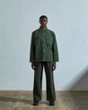 Full-length front view of model wearing  #3001, coriander-green corduroy overshirt paired with Uskees darker green cord pants.