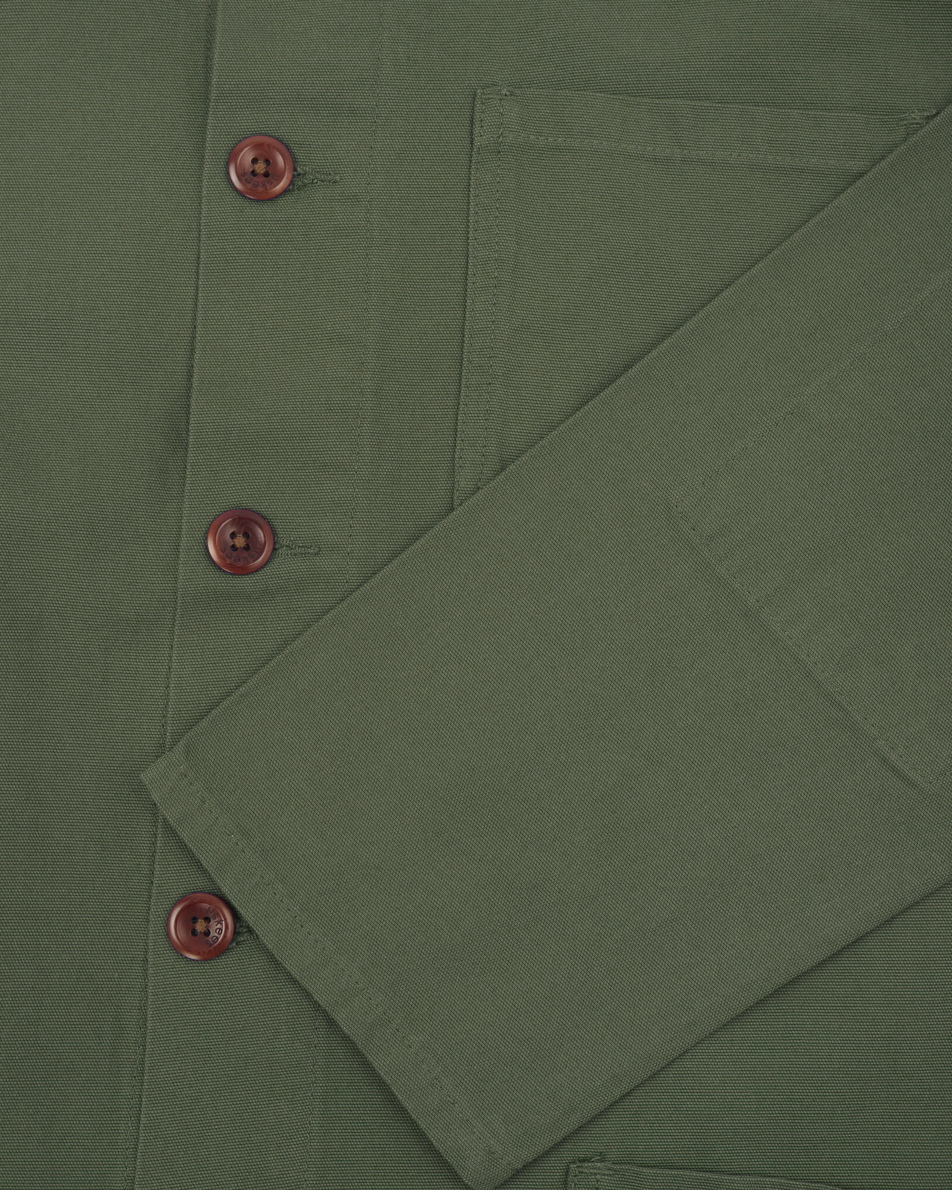 Close up shot of the sleeve and front buttons of an uskees coriander green men's overshirt