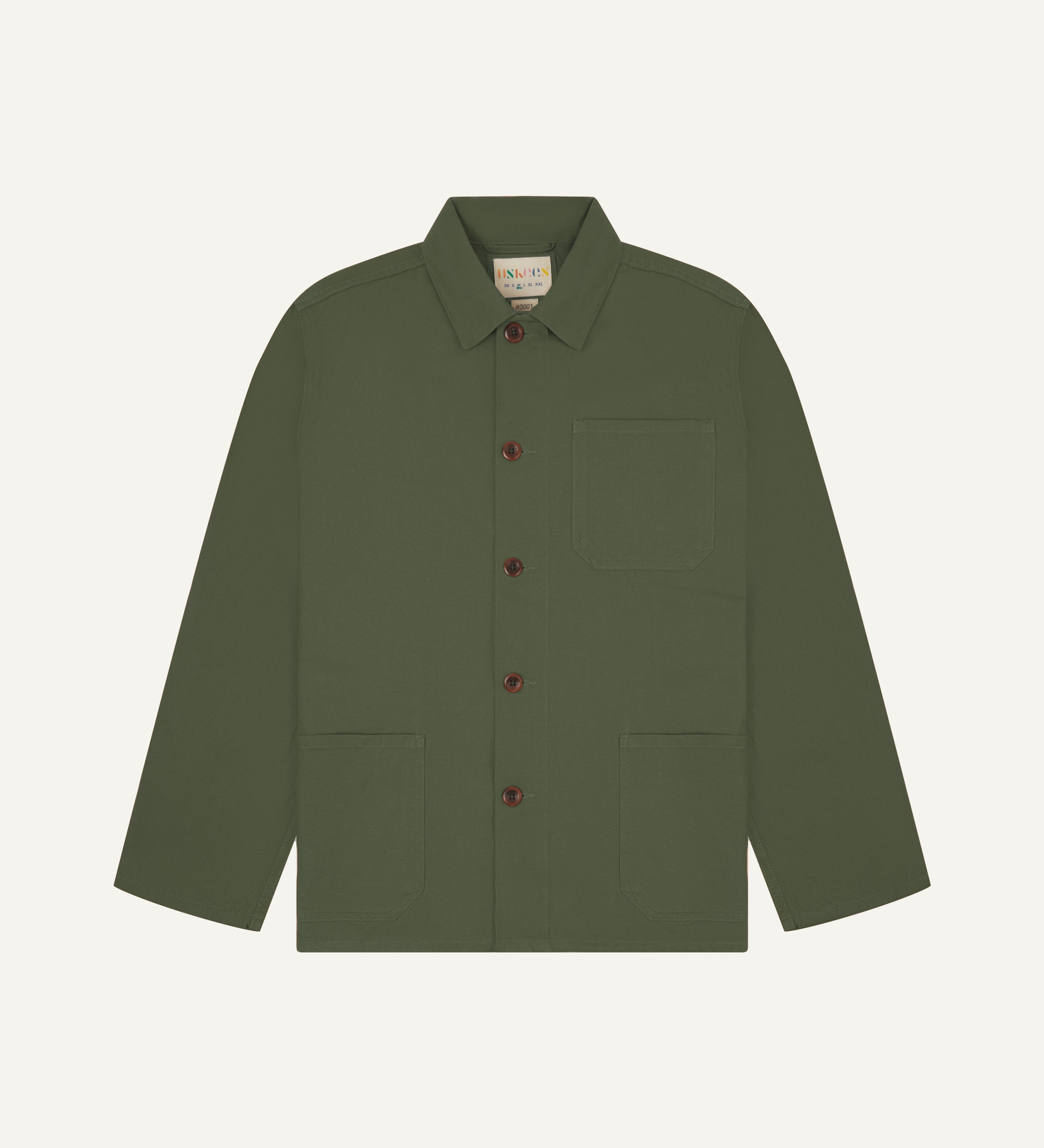 Front flat shot of coriander-green, buttoned organic cotton overshirt. Clear view of chest and hip pockets, corozo buttons and Uskees branding label.