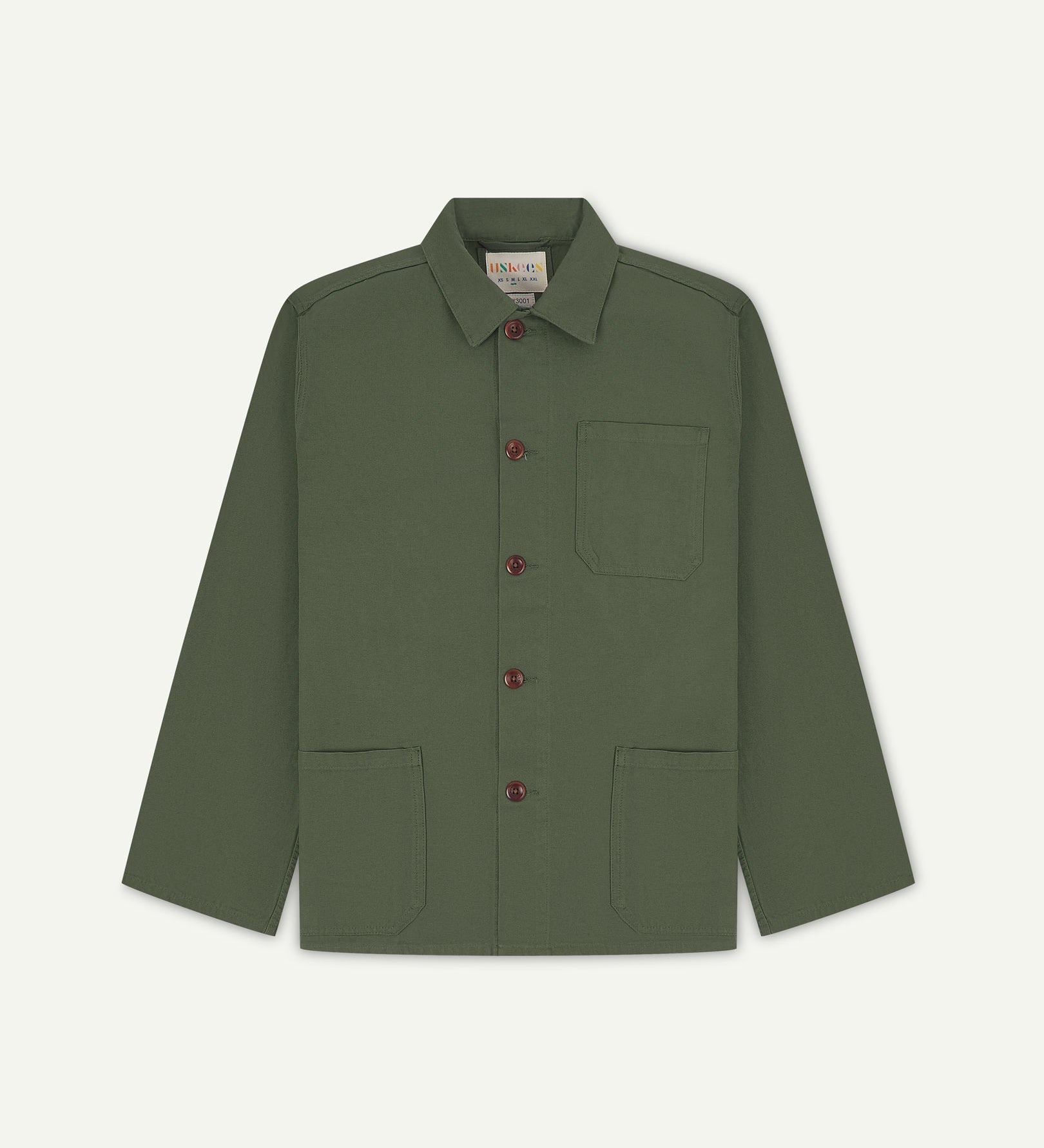 Front flat shot of coriander-green, buttoned organic cotton overshirt. Clear view of chest and hip pockets, corozo buttons and Uskees branding label.