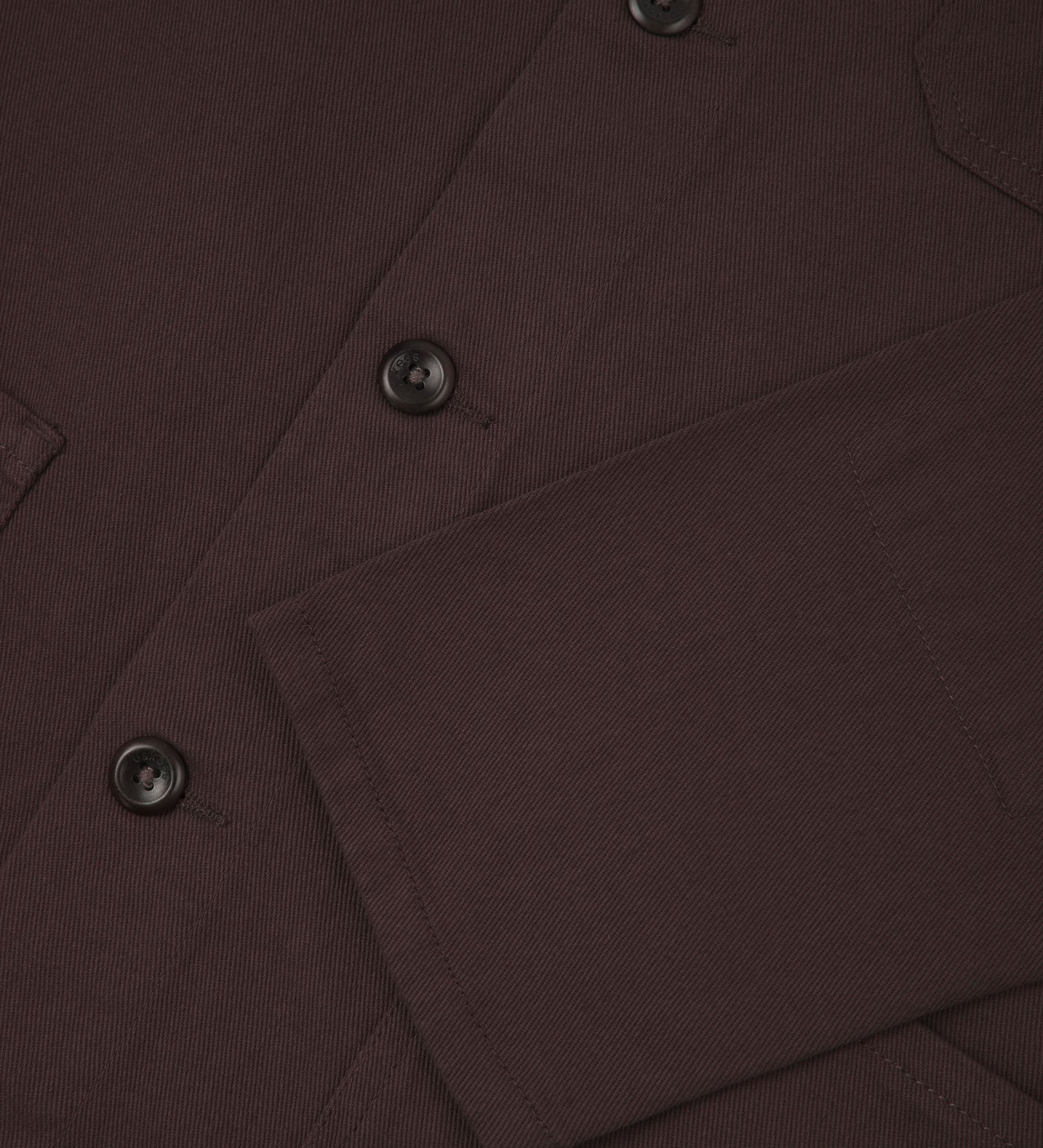 View of the mid-section and sleeve of the 3001 Uskees button-down drill overshirt in burgundy-brown with focus on cuff, placket and hip pocket.