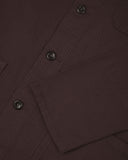 View of the mid-section and sleeve of the 3001 Uskees button-down drill overshirt in burgundy-brown with focus on cuff, placket and hip pocket.