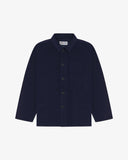 Front flat shot of deep indigo, buttoned corduroy overshirt. Clear view of corozo buttons, 3 pockets and Uskees branding label.