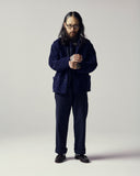 Model wearing the 3001 Uskees button-down corduroy overshirt in deep indigo layered with various Uskees apparel.