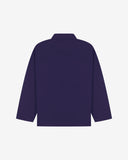Back view of deep indigo, buttoned organic cotton overshirt with view of reinforced elbow area and boxy silhouette.