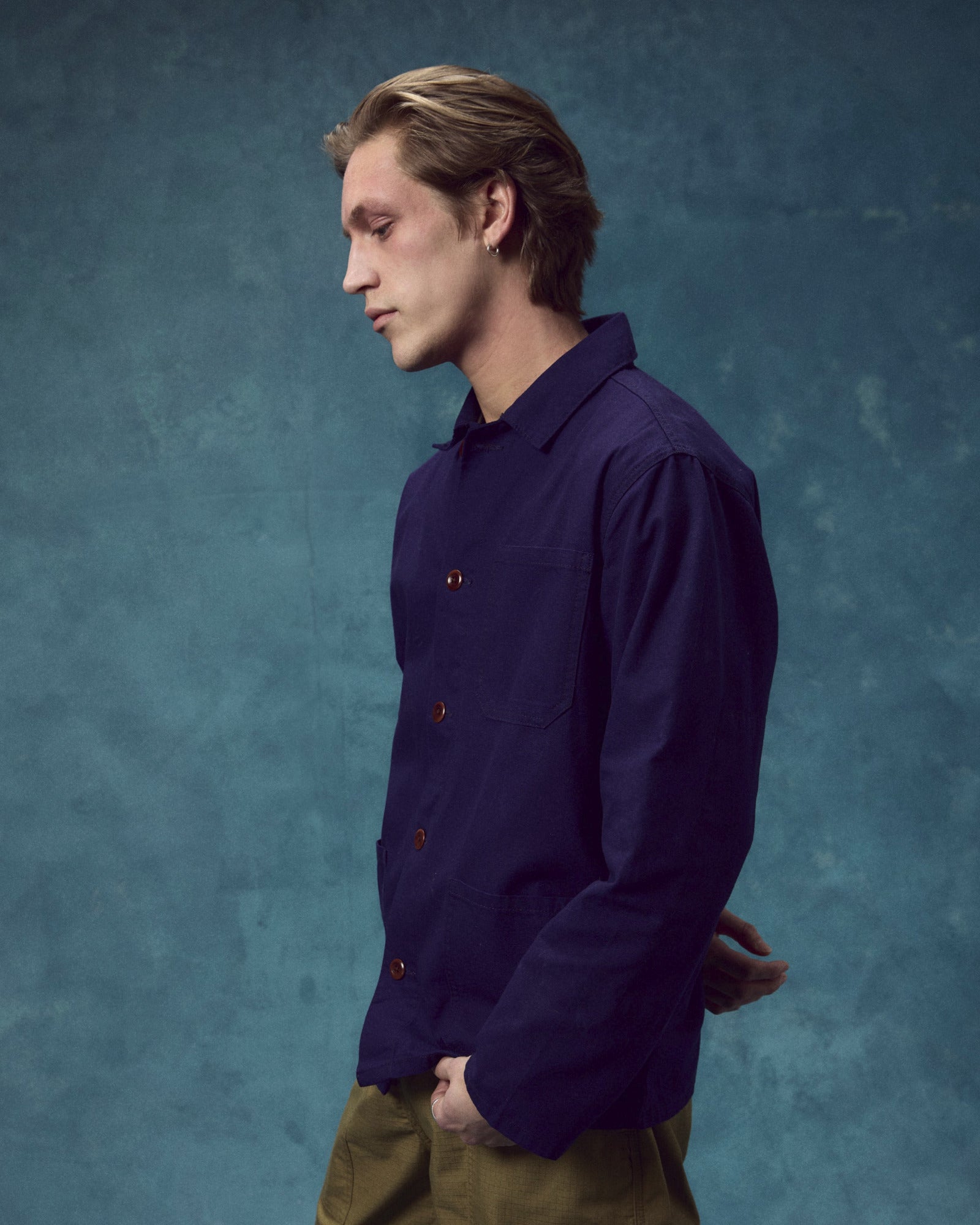 Side view of man wearing the 3001 deep indigo organic cotton overshirt from Uskees. Fully secured with corozo buttons.