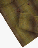 Closer view of mid section of woodland green check, buttoned Pennine wool overshirt from Uskees. Focus on cuff, pocket, corozo button and Pennine wool texture.