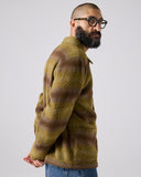 Model wearing Delph woodland green check, buttoned Pennine wool overshirt. Showing arm and paired with jeans.