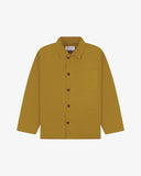 Front flat shot of mustard-yellow, buttoned organic cotton overshirt. Clear view of chest and hip pockets, corozo buttons and simple, boxy shape.