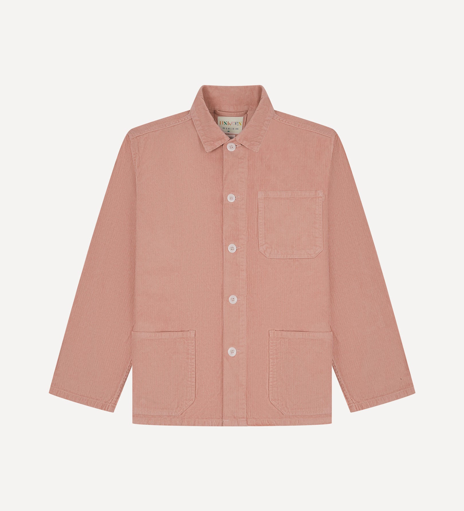 Front flat shot of dusty pink, buttoned corduroy overshirt. Clear view of chest and hip pockets, corozo buttons and Uskees branding label.
