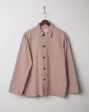Dusty pink coloured, buttoned organic cotton overshirt from Uskees presented on hanger. Clear view of breast and hip pocket and corozo buttons.
