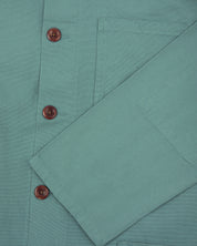 Close up shot of uskees eucalyptus green men's overshirt showing corozo buttons