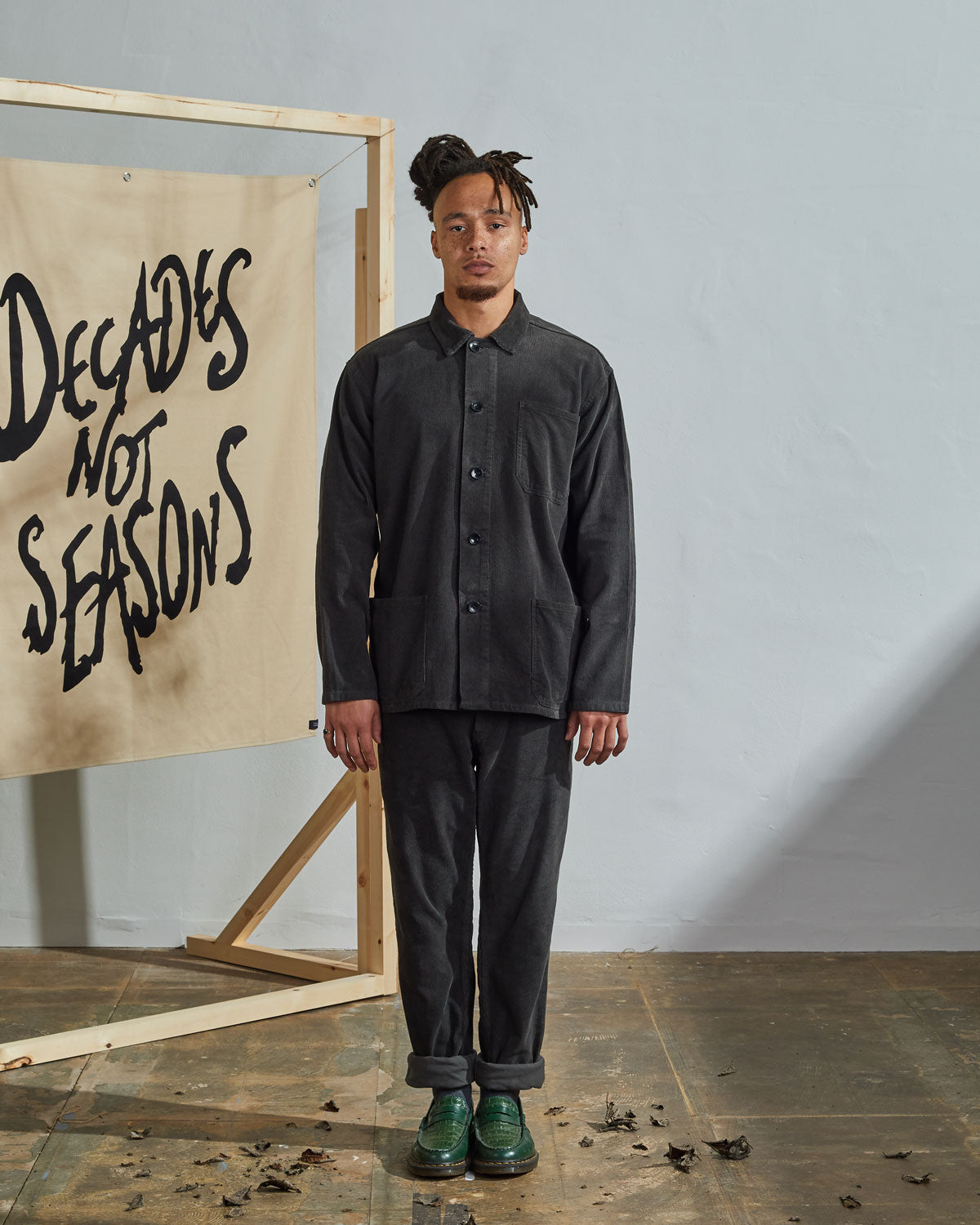 Full-length front view of model wearing unfastened #3001, faded-black corduroy overshirt paired with matching Uskees faded black cord pants.