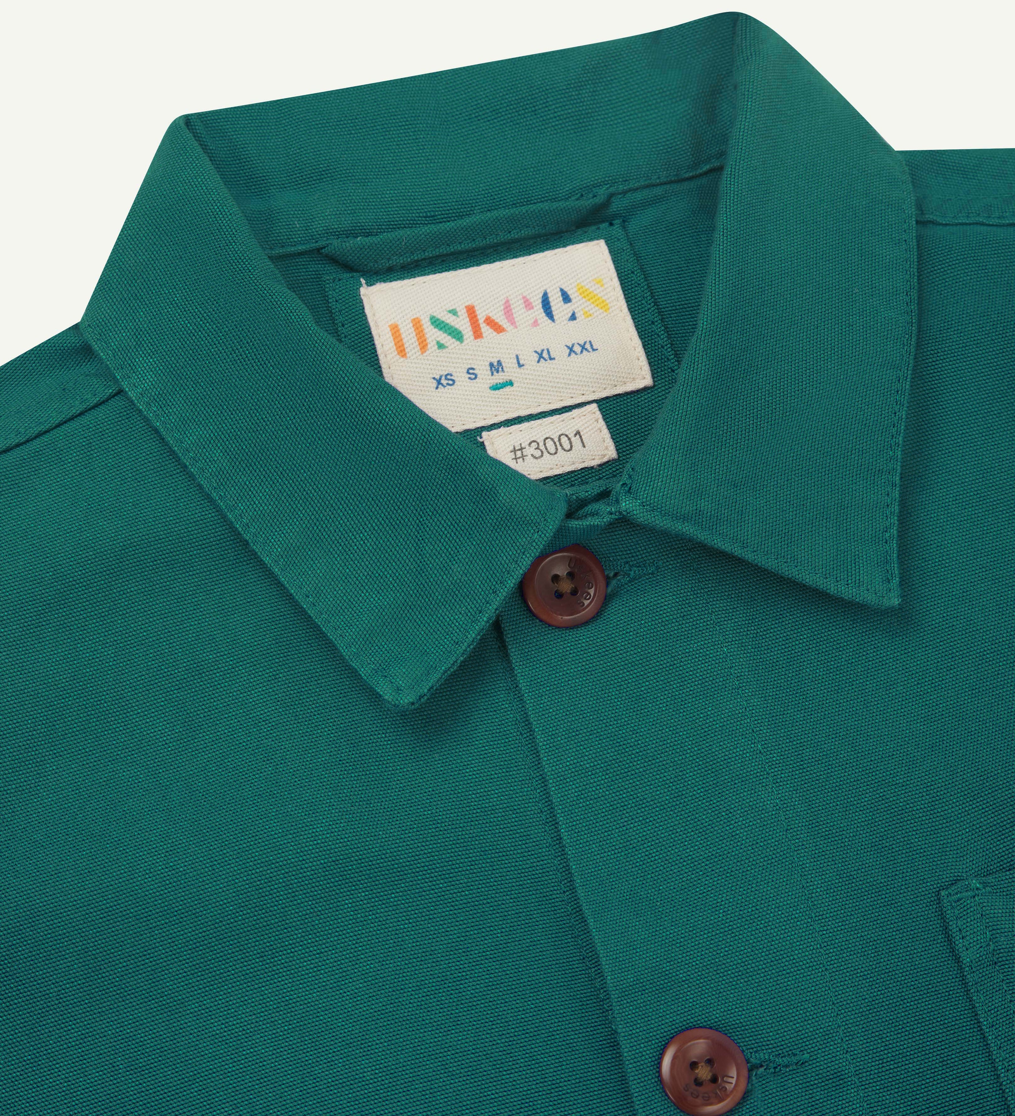 Close up of the collar and neck label of a foam green uskees overshirt