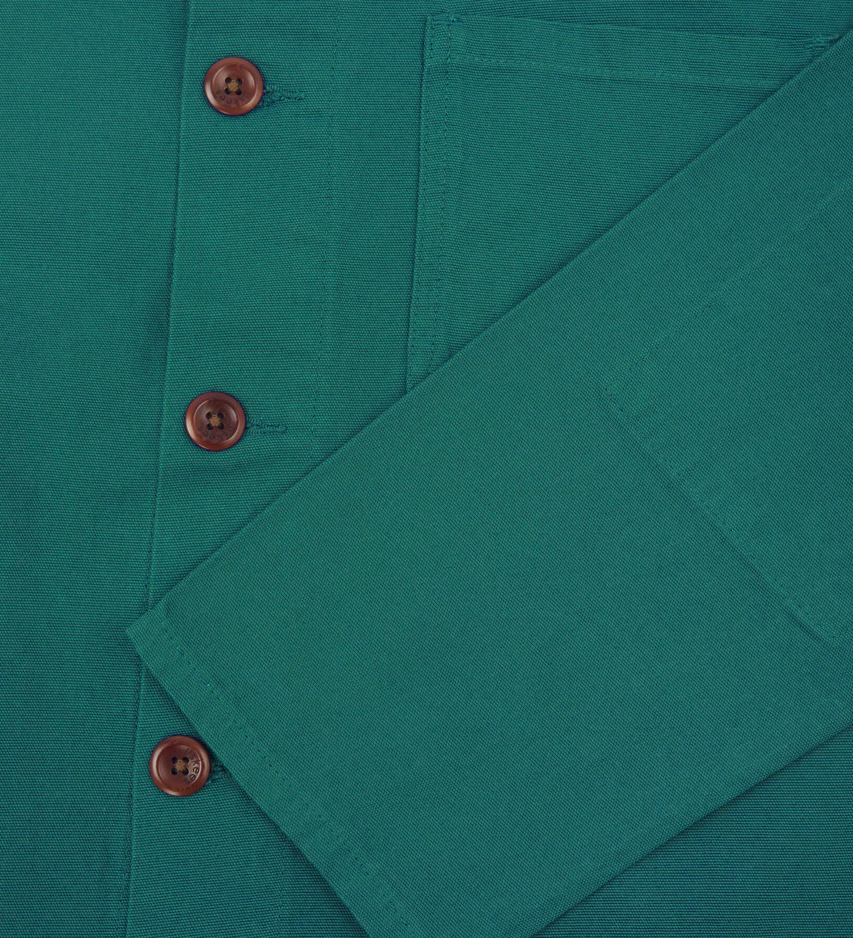 Detail shot of uskees foam green men's overshirt showing the sleeve and corozo buttons.