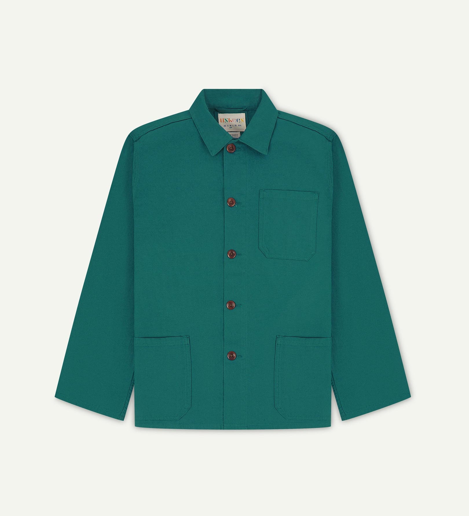 Front flat shot of foam green, buttoned organic cotton overshirt. Clear view of chest and hip pockets, corozo buttons and Uskees branding label.