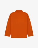 Back view of golden-orange, buttoned organic cotton overshirt with view of reinforced elbow area and boxy silhouette.