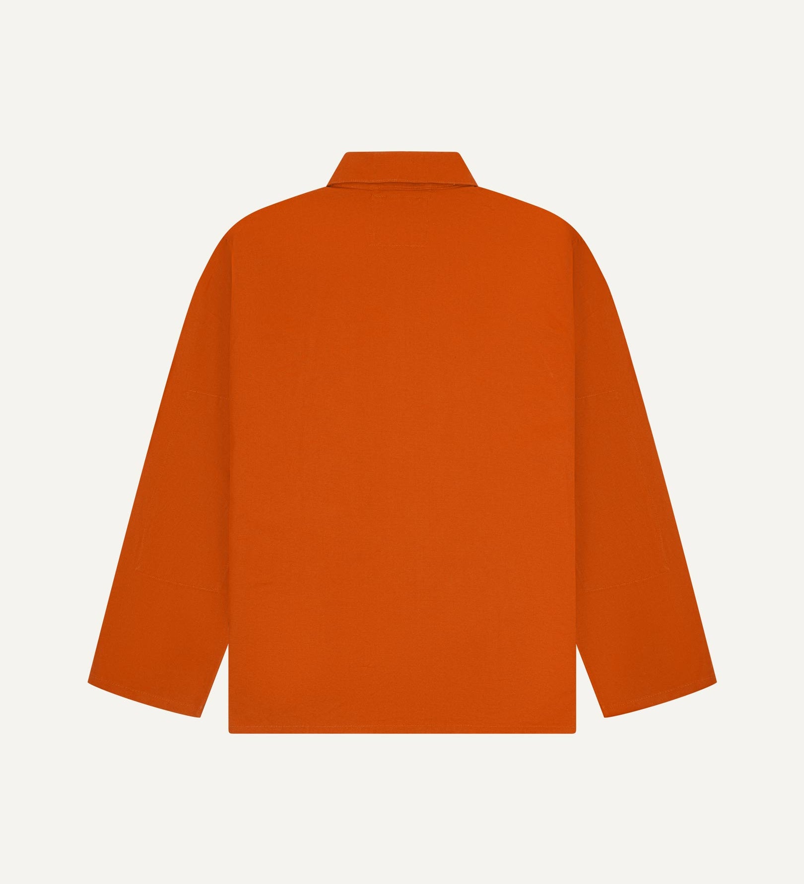 Back view of golden-orange, buttoned organic cotton overshirt with view of reinforced elbow area and boxy silhouette.