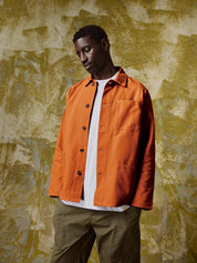 Full-length front view of model wearing 3001 gold-orange over shirt paired with khaki pants.
