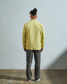 Full-length rear view of model wearing #3001, 'lime' organic cotton over shirt with reinforced elbows.