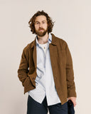 Top-half view modelling 3001 Uskees men's linen blend brown linen blend overshirt. Paired with blue and white pinstripe Uskees shirt.