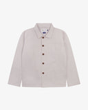 Front flat shot of lunar stone (light grey), buttoned organic cotton overshirt. Clear view of corozo buttons, 3 pockets and Uskees branding label.