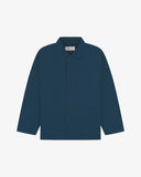 Front flat shot of maya blue, buttoned organic cotton overshirt. Clear view of corozo buttons, 3 pockets and Uskees branding label.