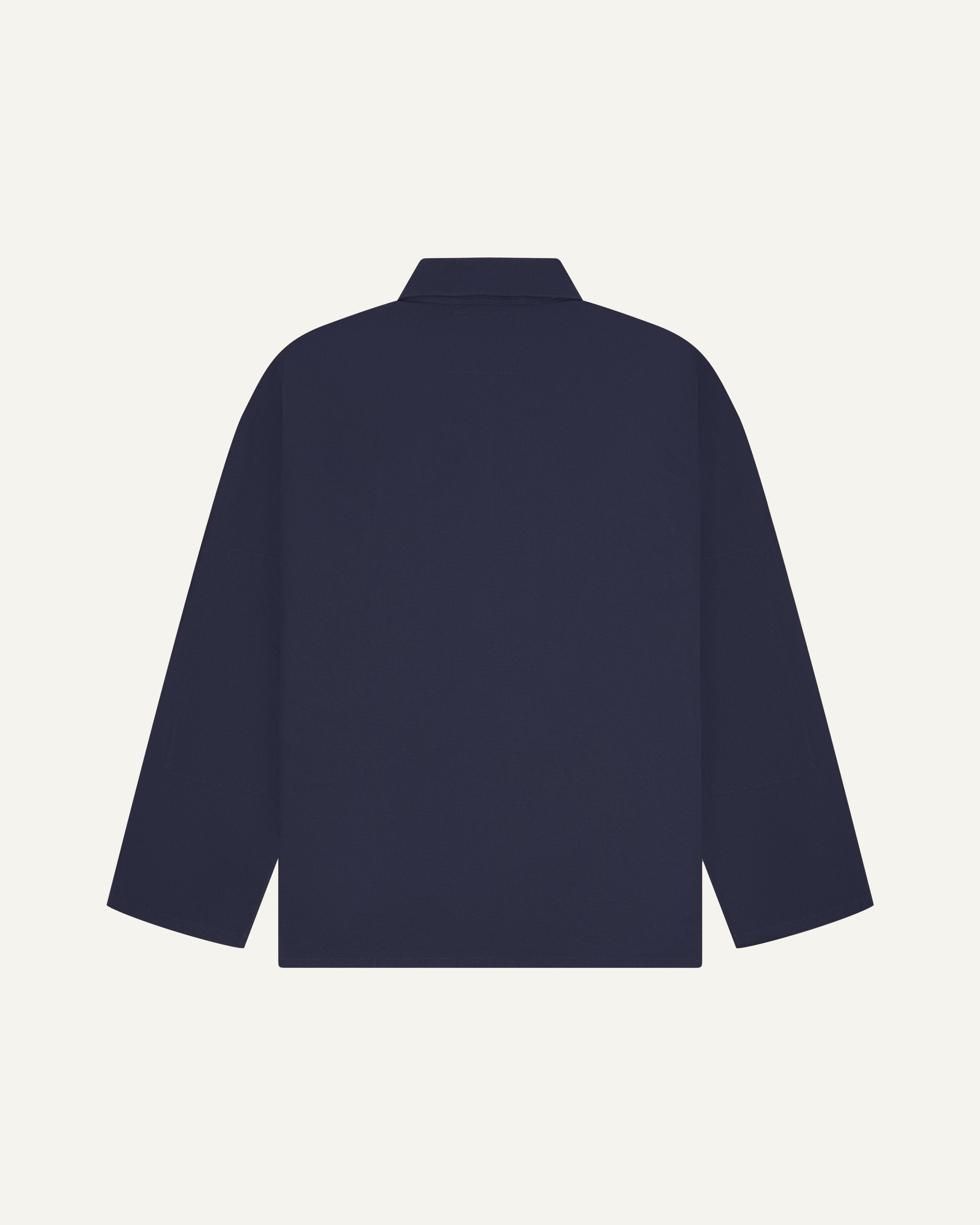 Back view of midnight blue, buttoned organic cotton overshirt with view of reinforced elbow area and boxy silhouette.