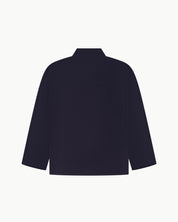 Back view of midnight blue, buttoned corduroy overshirt with view of reinforced elbow area and boxy silhouette.