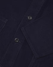Closer view of mid section of midnight blue, buttoned corduroy overshirt from Uskees. Focus on cuff, pockets, corozo buttons and corduroy texture.