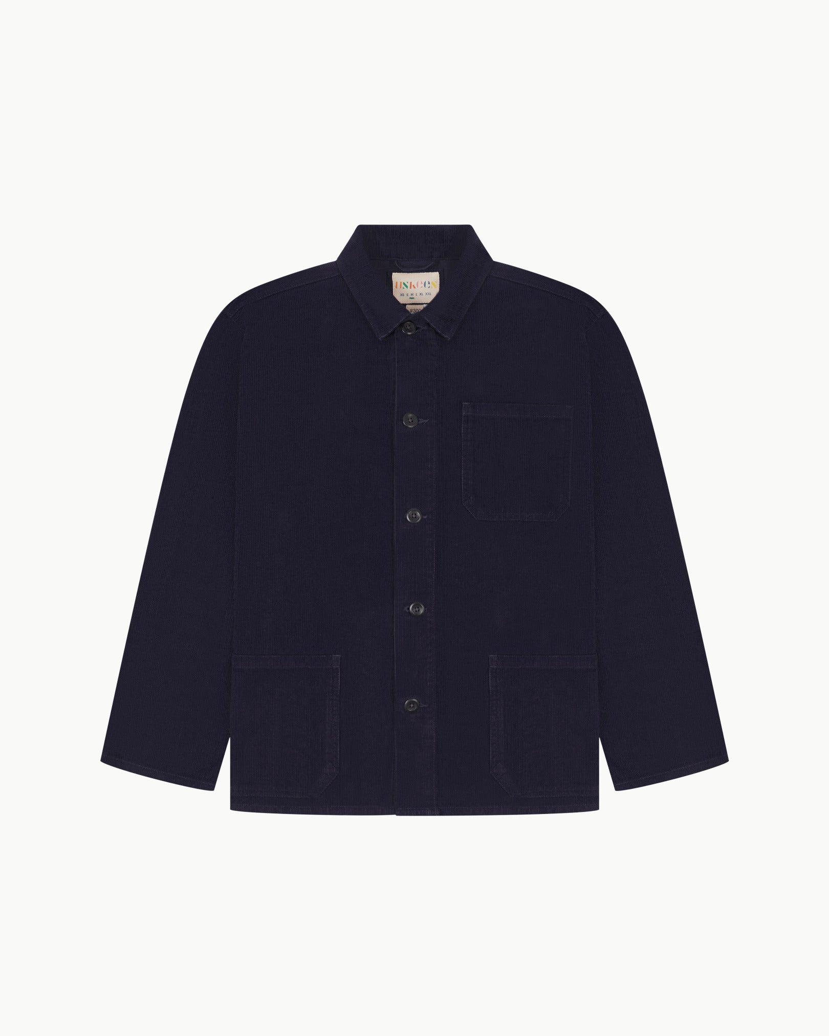 Front flat shot of midnight blue, buttoned corduroy overshirt. Clear view of chest and hip pockets, corozo buttons and Uskees branding label.