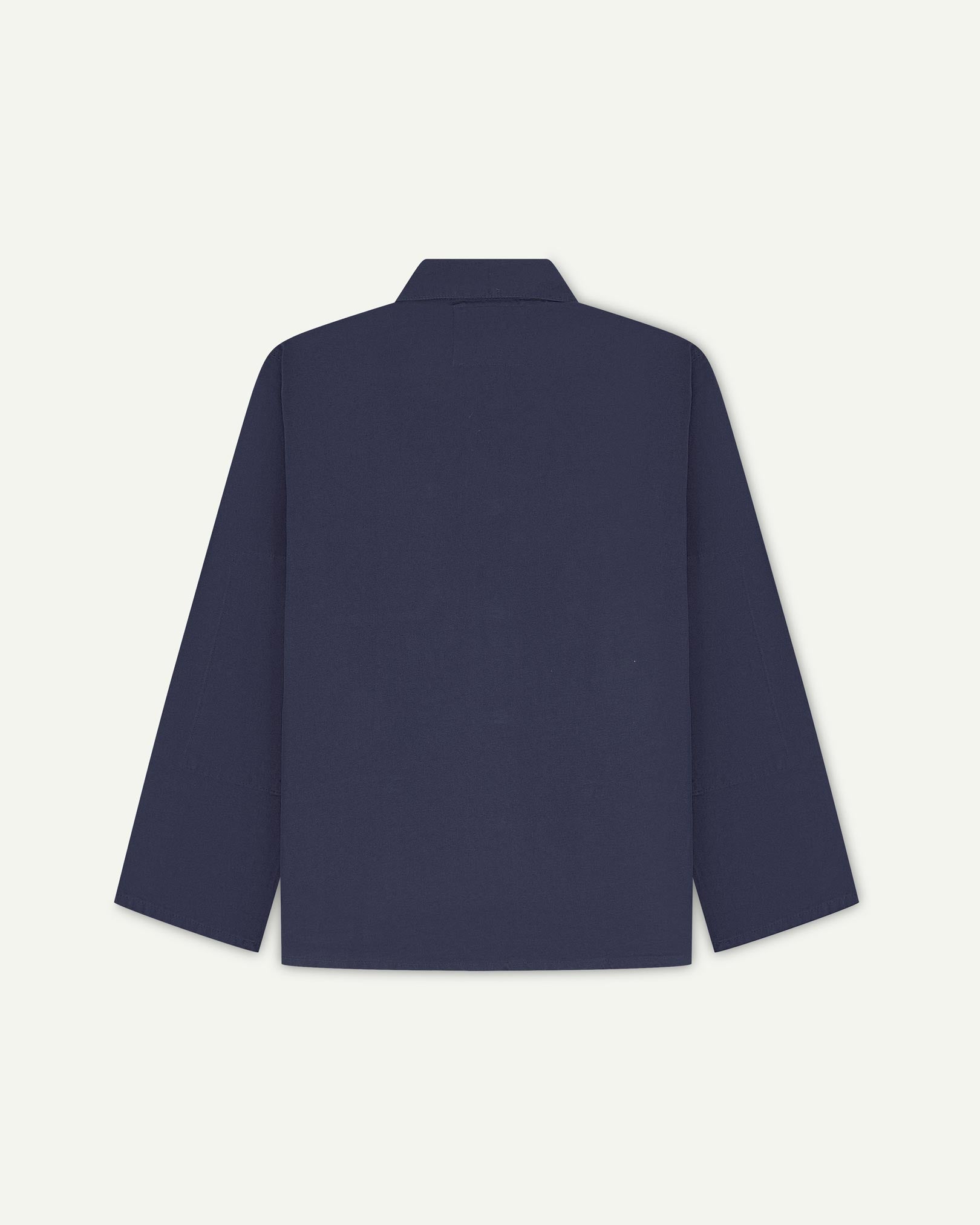 Back view of midnight blue, buttoned organic cotton overshirt with view of reinforced elbow area and boxy silhouette.