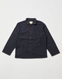 Front flat shot of midnight blue, buttoned organic cotton overshirt. Clear view of chest and hip pockets, corozo buttons and Uskees branding label.  Zero waste production.