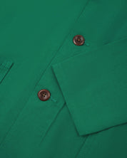 Closer view of mid section of mint green, buttoned organic cotton overshirt from Uskees. Focus on cuff, placket and corozo buttons.