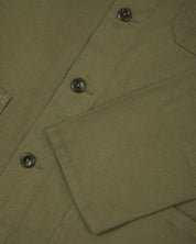 View of the mid-section and sleeve of the 3001 Uskees button-down drill overshirt in moss-green with focus on cuff, placket and hip pocket.