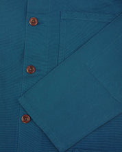 Close up detail shot of uskees peacock blue overshirt showing sleeve and front corozo buttons