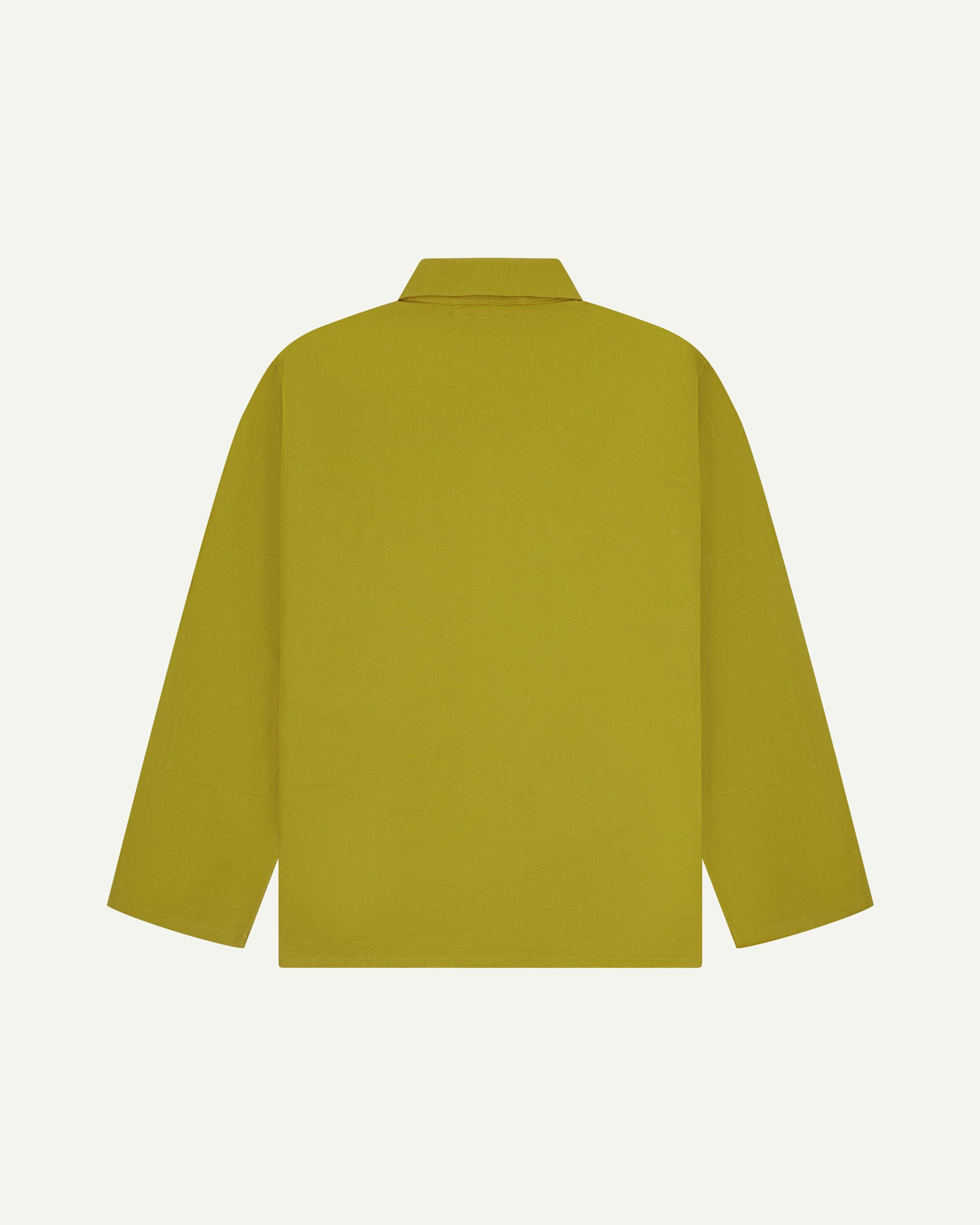 Reverse of yellow-green pear-coloured buttoned organic cotton drill overshirt from Uskees. Showing reinforced elbows and boxy silhouette.