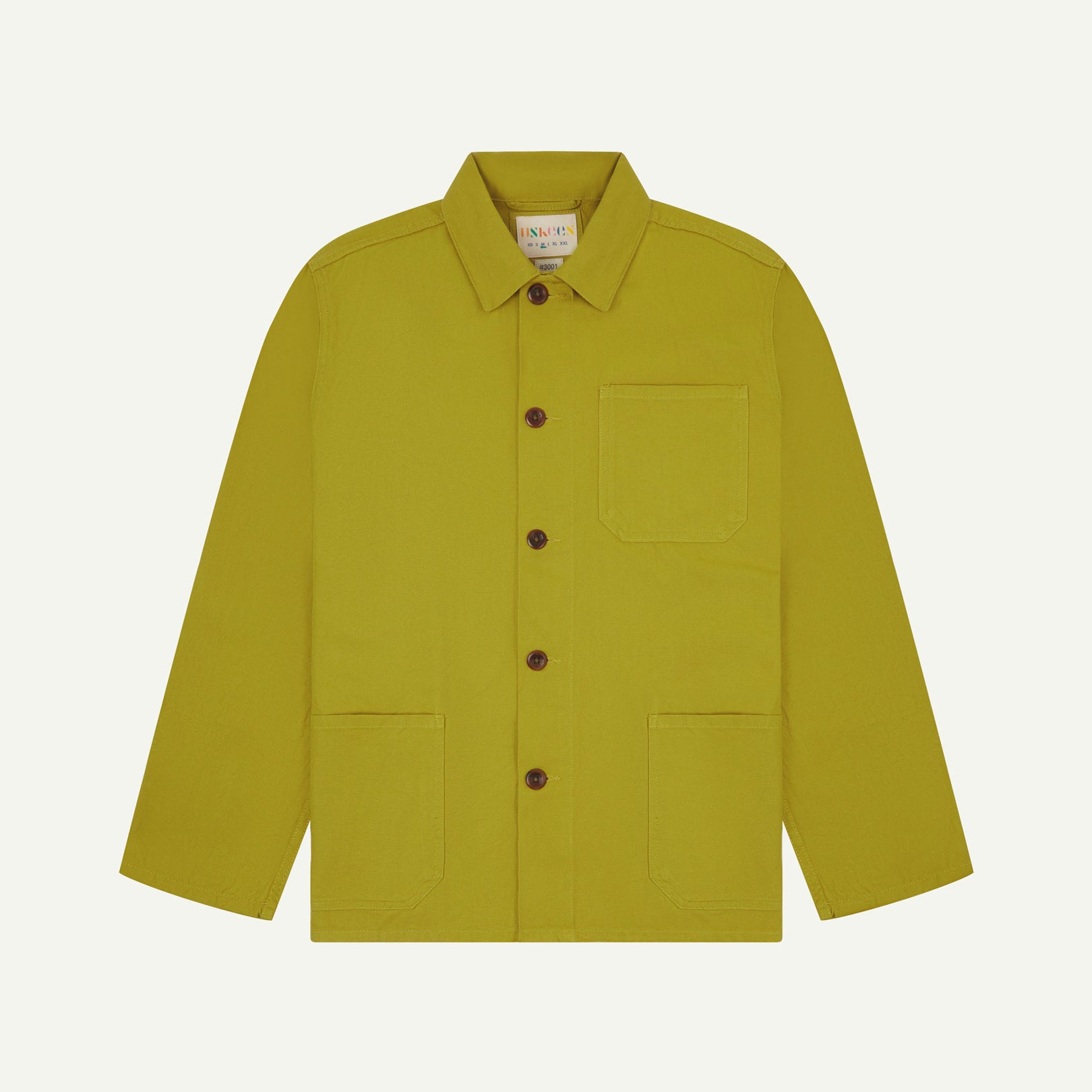 Front flat shot of yellow-green pear-coloured buttoned drill overshirt. Clear view of corozo buttons, 3 pockets and Uskees branding label.
