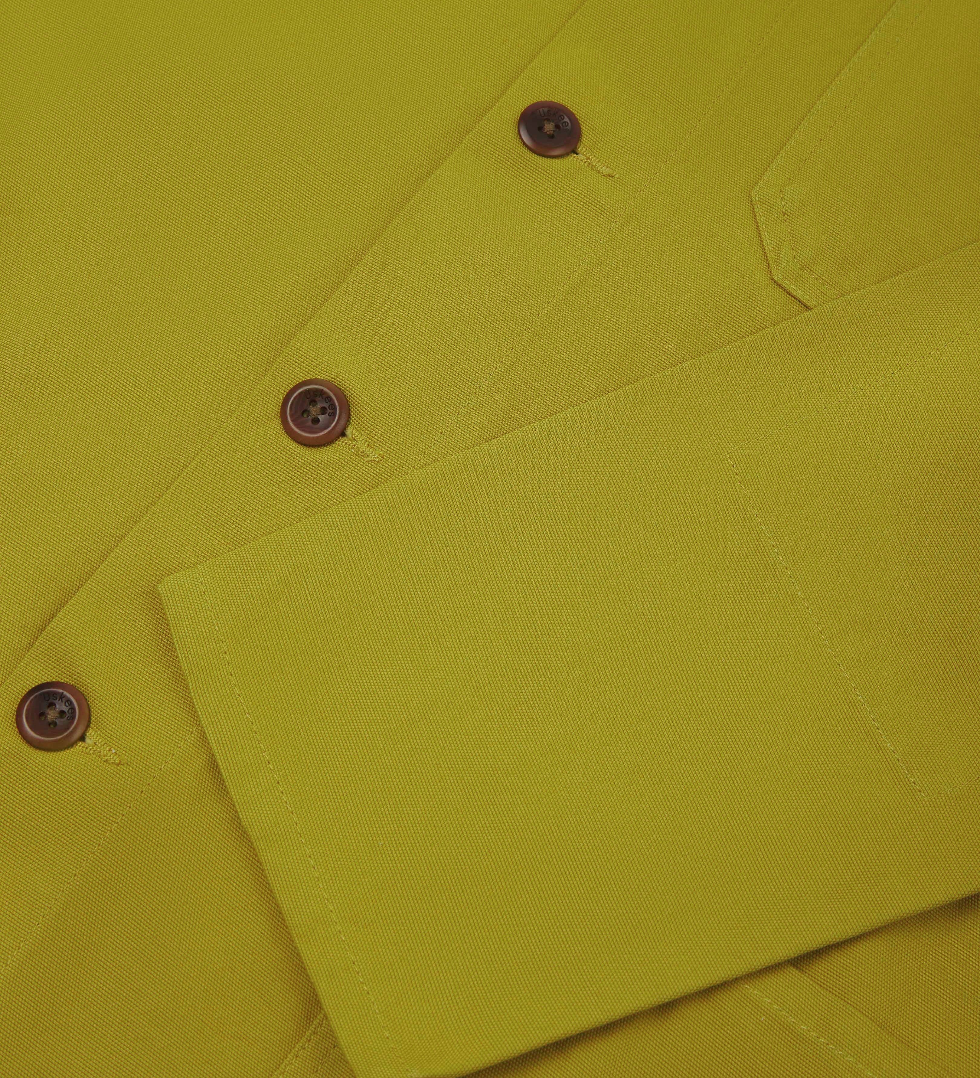Front close up shot of uskees signature men's overshirt in pear green showing corozo button fastening