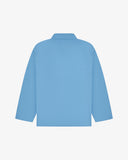 Back view of powder blue, buttoned organic cotton overshirt with view of reinforced elbow area and boxy silhouette.