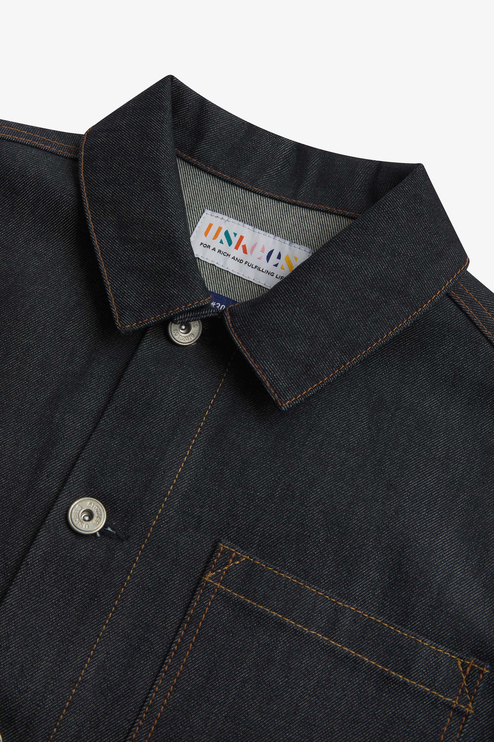 Close-up top-half view of #3001, raw orta denim overshirt. With focus on collar, hanging loop and nickel-free buttons.