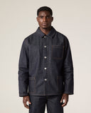 Front view of male model wearing Uskees raw orta denim workwear pants in dark indigo with matching denim overshirt. 
