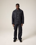 Full-length front view of male model wearing Uskees raw orta denim workwear pants in dark indigo with matching denim overshirt. 
